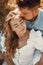 Happy couple sitting on bale in farmland