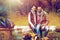 Happy couple sitting on bench near camp fire