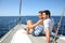 Happy couple sitting on a deck of sailing boat