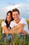 Happy couple sitting on a meadow or grainfield