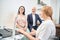 Happy couple sitting on medical examination couch after fetal ultrasound