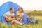 Happy couple sitting near tent with guitar