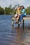 Happy Couple Sitting On A Pier By Lake