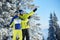 Happy couple skiers posing on skis before skiing at ski resort. Clear blue sky, snow-covered fir trees on background.