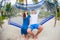 Happy couple on summer vacation relaxing in hammock