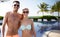 Happy couple in swimwear hugging over hotel resort
