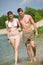 Happy couple in swimwear walk in lake