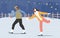 Happy Couple of Teenagers Skate at Night City Ice Rinks, Outdoor Activities at Winter Park. Family Christmas Holidays