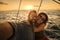 Happy couple of tourist take selfie and smile enjoying the summer sunset in holiday vacation - yacht luxury lifestyle people -