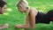 Happy couple training plank exercise in summer park. Sport couple concept