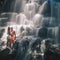 Happy couple travels to waterfall, Indonesia. Bali