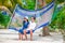 Happy couple on tropical vacation relaxing in hammock