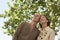 Happy Couple Under Tree Looking Away