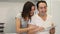 Happy Couple Uses Tablet while Sitting At the Kitchen Table