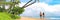 Happy couple walking on beach vacation in Hawaii, Maui island, USA summer travel. Panoramic banner landscape of people
