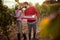 Happy couple walking through vineyard. Family grape harvesting