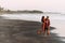 A happy couple walks along the beach at sunset. Lovers on the coast. Man and woman are resting on the sea. Beautiful couple have