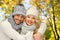 Happy couple in warm clothes over autumn