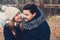 Happy couple in warm knitted hat and scarf walking outdoor in autumn forest