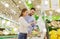 Happy couple weighing cabbage on scale at grocery