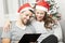 Happy couple write list for christmas on sofa