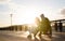 Happy couple - young woman with disabled man in wheelchair rests together outdoors