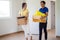 Happy couples hold paper boxes that hold personal belongings and move items to their new home