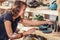 Happy craftsman with ceramic crockery against shelves in studio