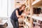 Happy craftsman with ceramic crockery against shelves in studio