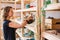 Happy craftsman with ceramic crockery against shelves in studio