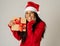 Happy crazy excited young woman in santa claus hat with christmas present laughing and smiling