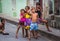 Happy Cuban children capture portrait in poor colorful colonial alley with smile face, in old Havana, Cuba, America.