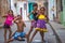 Happy Cuban girl capture portrait in poor colorful colonial alley with smile face, in old city, Cuba, America.