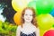 Happy curly girl with colorful balloon in summer park. Toning to