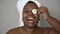 Happy curvy African woman having skin care spa day