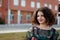 Happy curvy girl with curly hair in the street