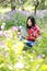 Happy cute Asian Chinese nature beautiful woman girl in a spring park enjoy free time read book