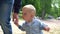 Happy cute baby boy with father walking in park