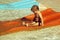 Happy cute baby boy slides from orange waterslide