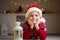 Happy cute boy lying on floor in red hat and wait Santa Claus