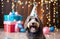 Happy cute labradoodle dog wearing a party hat celebrating at a birthday party