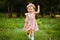 Happy cute little girl running on the grass in the park. Happiness