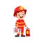 happy cute little kid wearing firefighter uniform and holding medic box