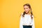 happy and cute schoolchild standing isolated on orange .