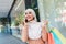 Happy cute young arab woman in hijab look ad about huge sale, enjoys modern shopping with a lot of packages