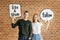 Happy cute young couple holding a thought bubble with social medHappy cute young couple holding a thought bubble with social media