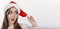 Happy and cute young woman in santa hat looking sideways