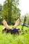 Happy cyclist enjoying relaxation lying barefoot in green grass