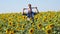 Happy dad carries his son through a field of sunflowers. Family farmers.