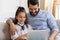 Happy dad cuddle with daughter use laptop together